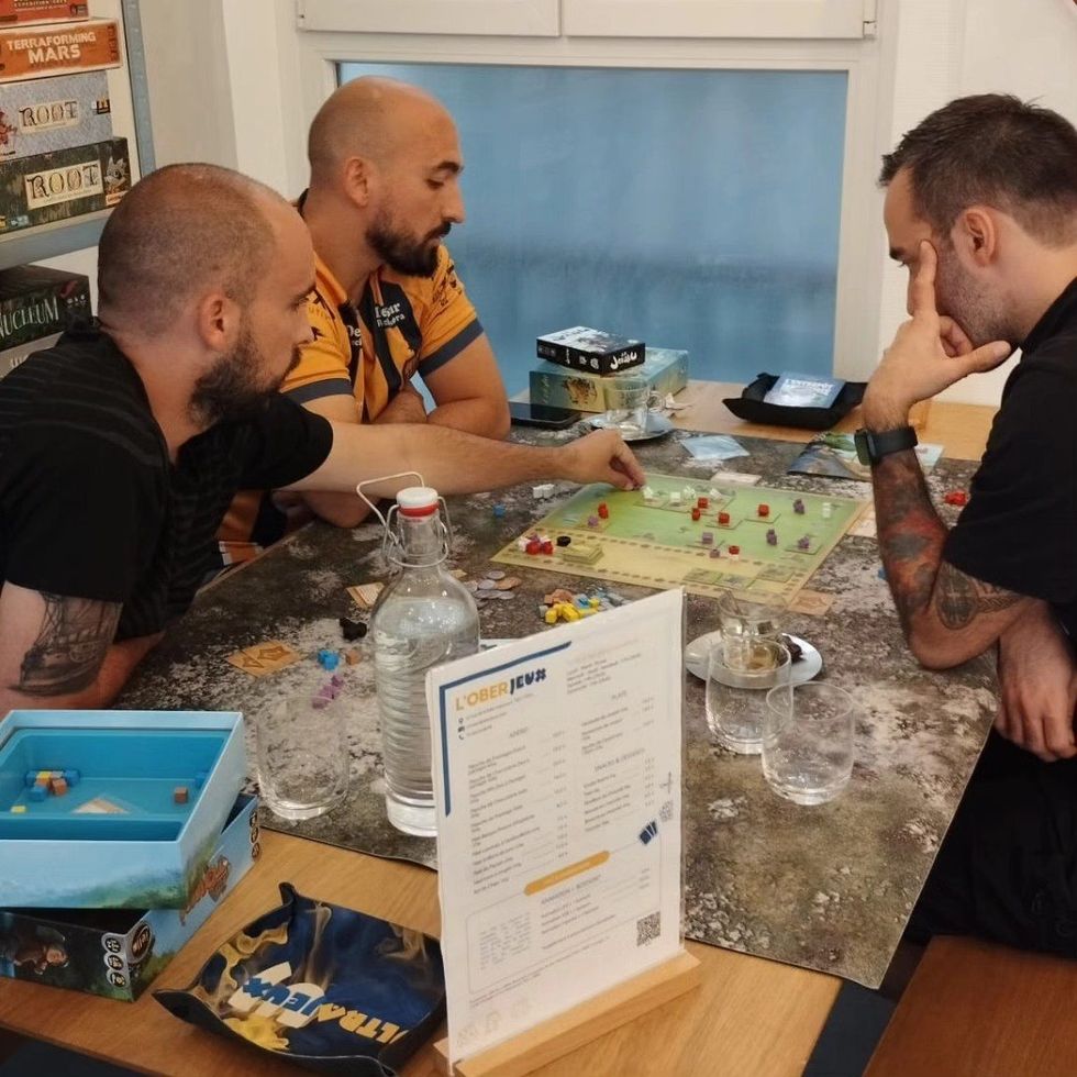 Photo of people playing board games at a board game bar in Paris, France.