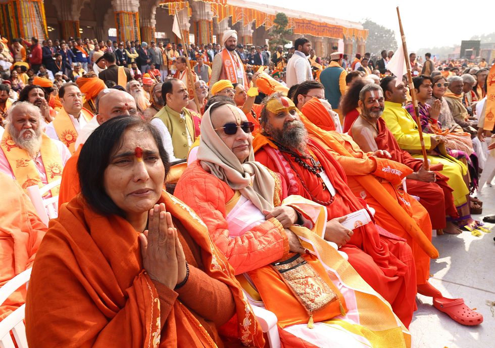 photo of people praying in colorful orange clothes