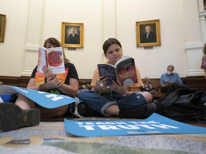 photo of people reading books on the floor of texas legislature
