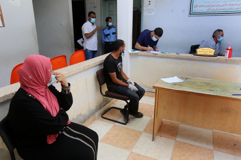 Photo of people signing marriage documents in a Palestinian court.