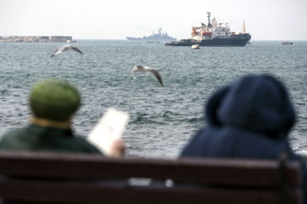 Photo of people sitting on a bench near the sea in Sevastopol, Crimea