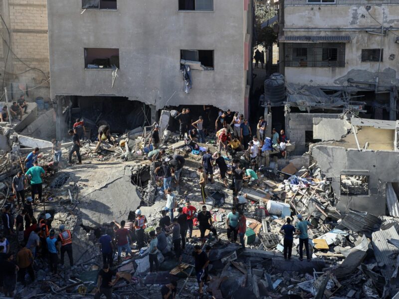 Photo of people standing amid rubble in Gaza