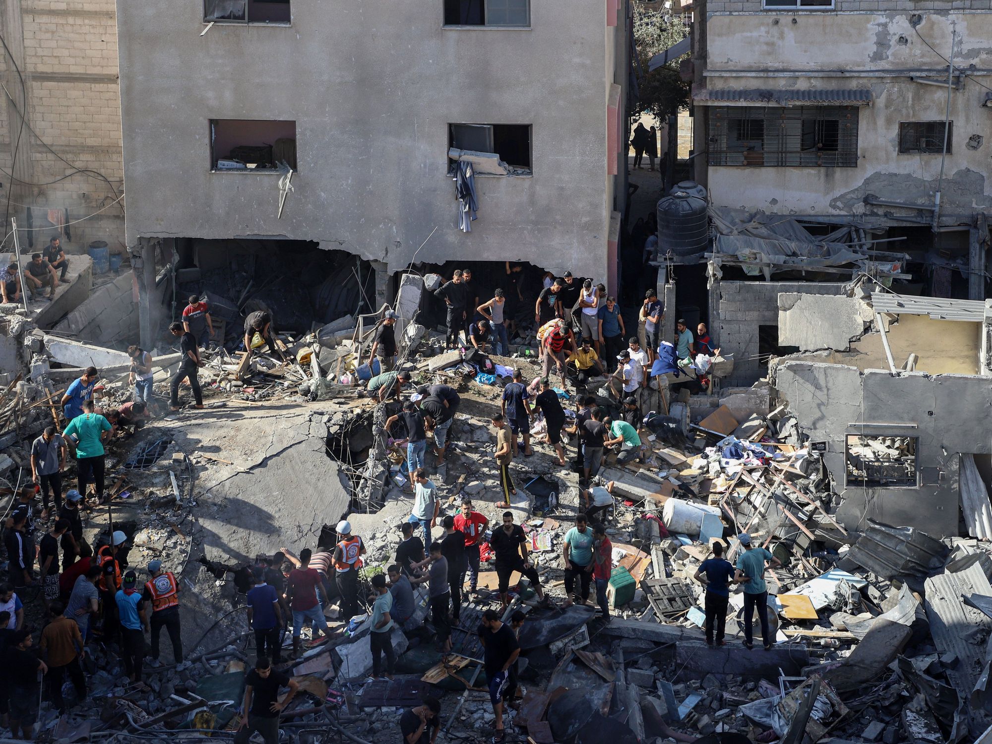 Photo of people standing amid rubble in Gaza