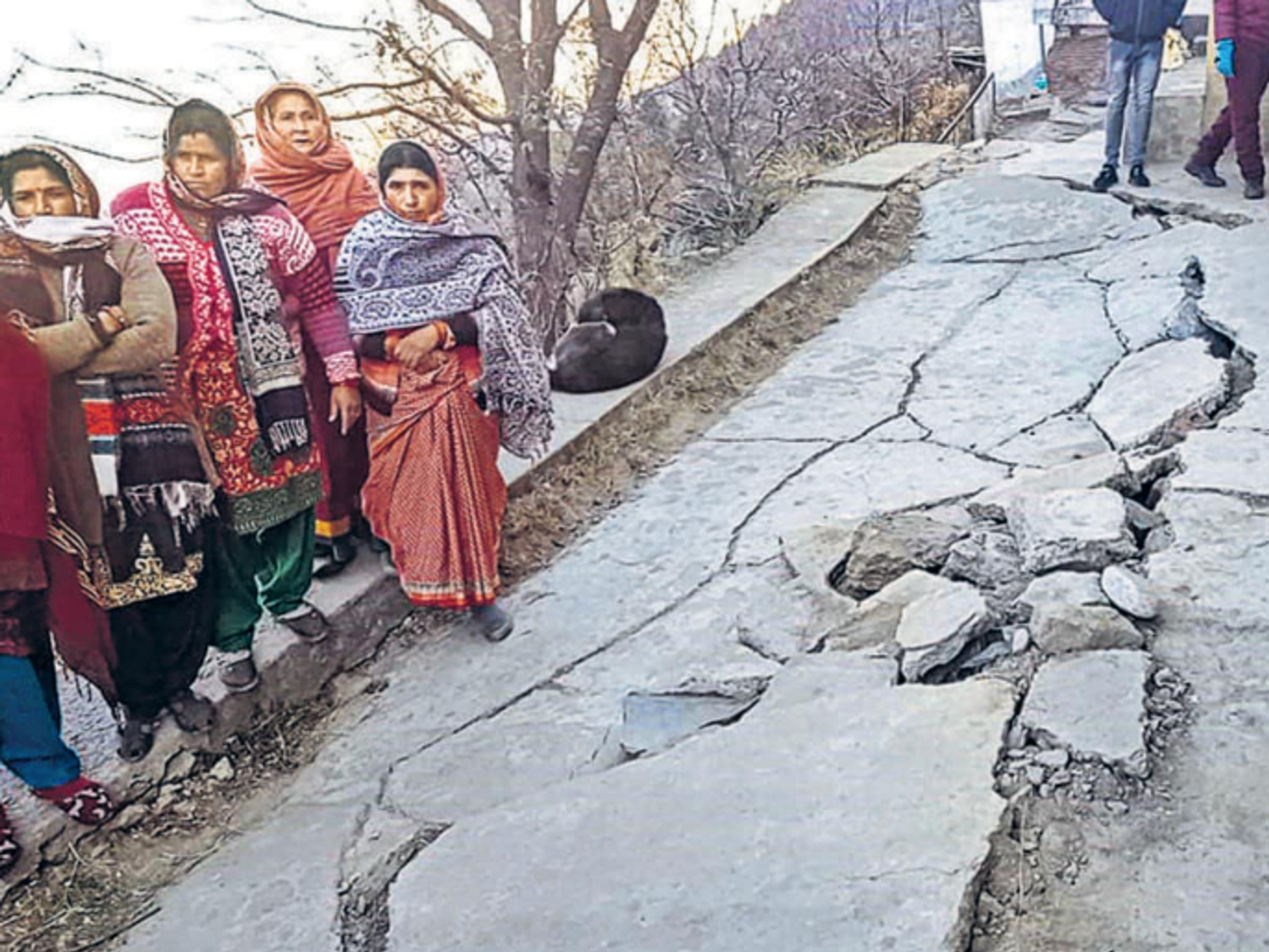 Photo of people standing next to a cracked road in Joshimath, India