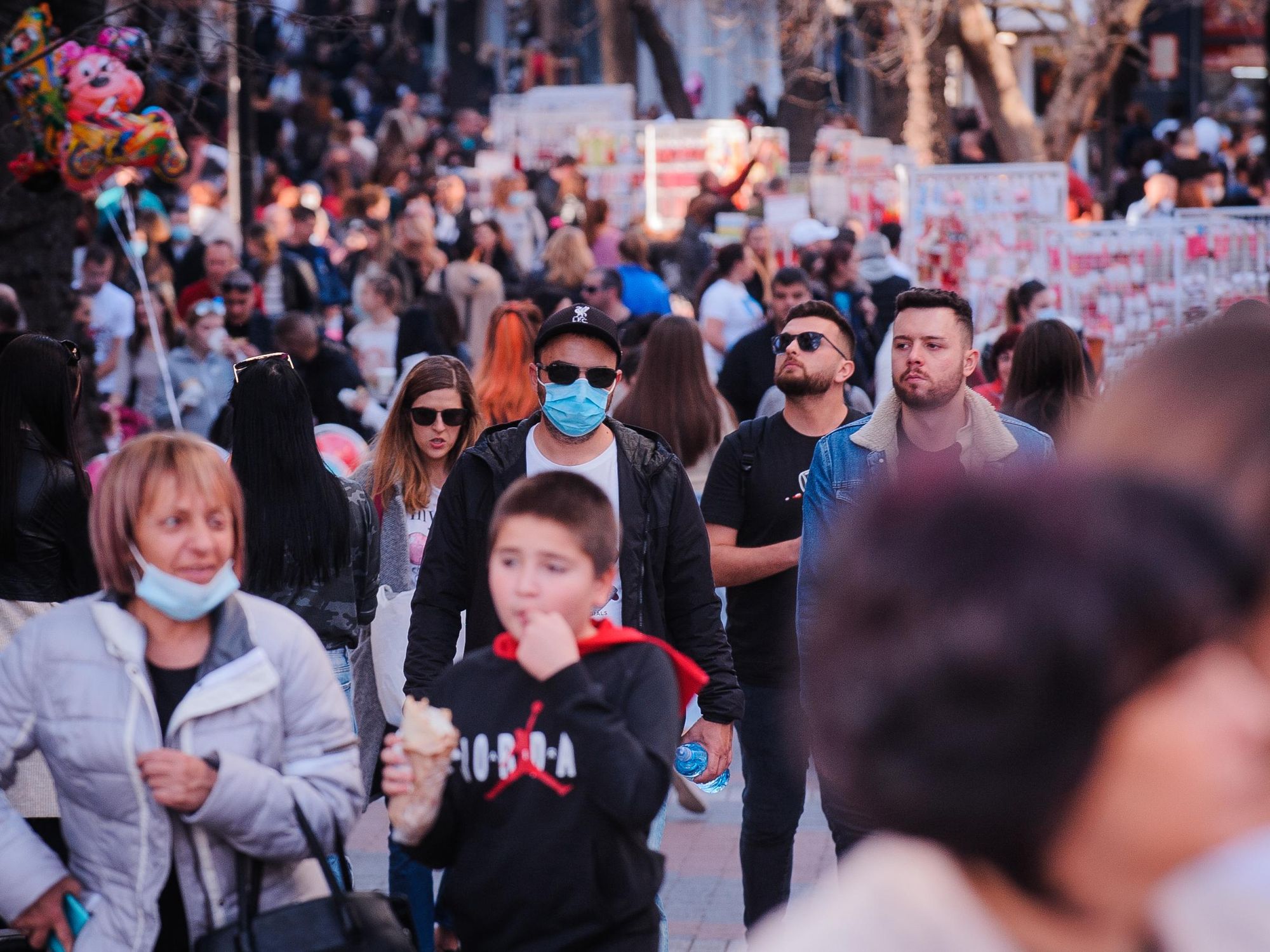 Photo of people walking in the streets of Plovdiv, Bulgaria, some wearing a facemask