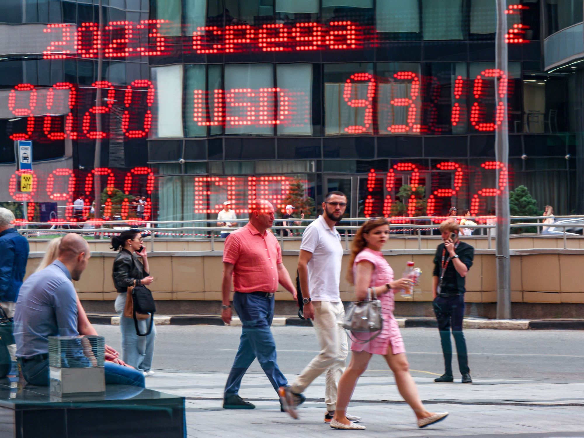 Photo of people walking past a currency exchange rate board in Moscow on July 20.