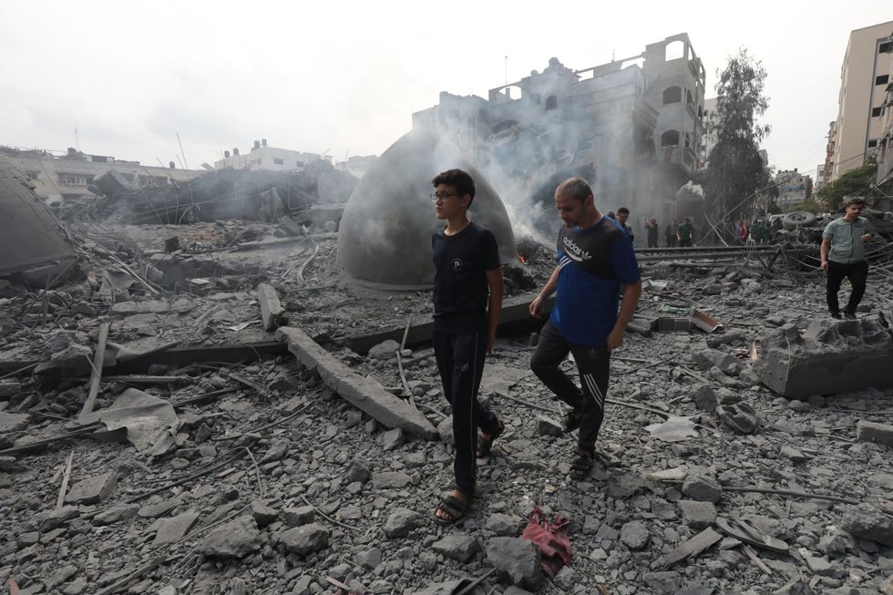 Photo of people walking through the rubble in Gaza on Oct. 9
