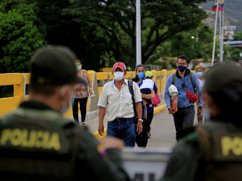 Photo of people walking toward border patrol officers as Colombia reopens its border with Venezuela after a 14-month closure to curb the spread of COVID-19.