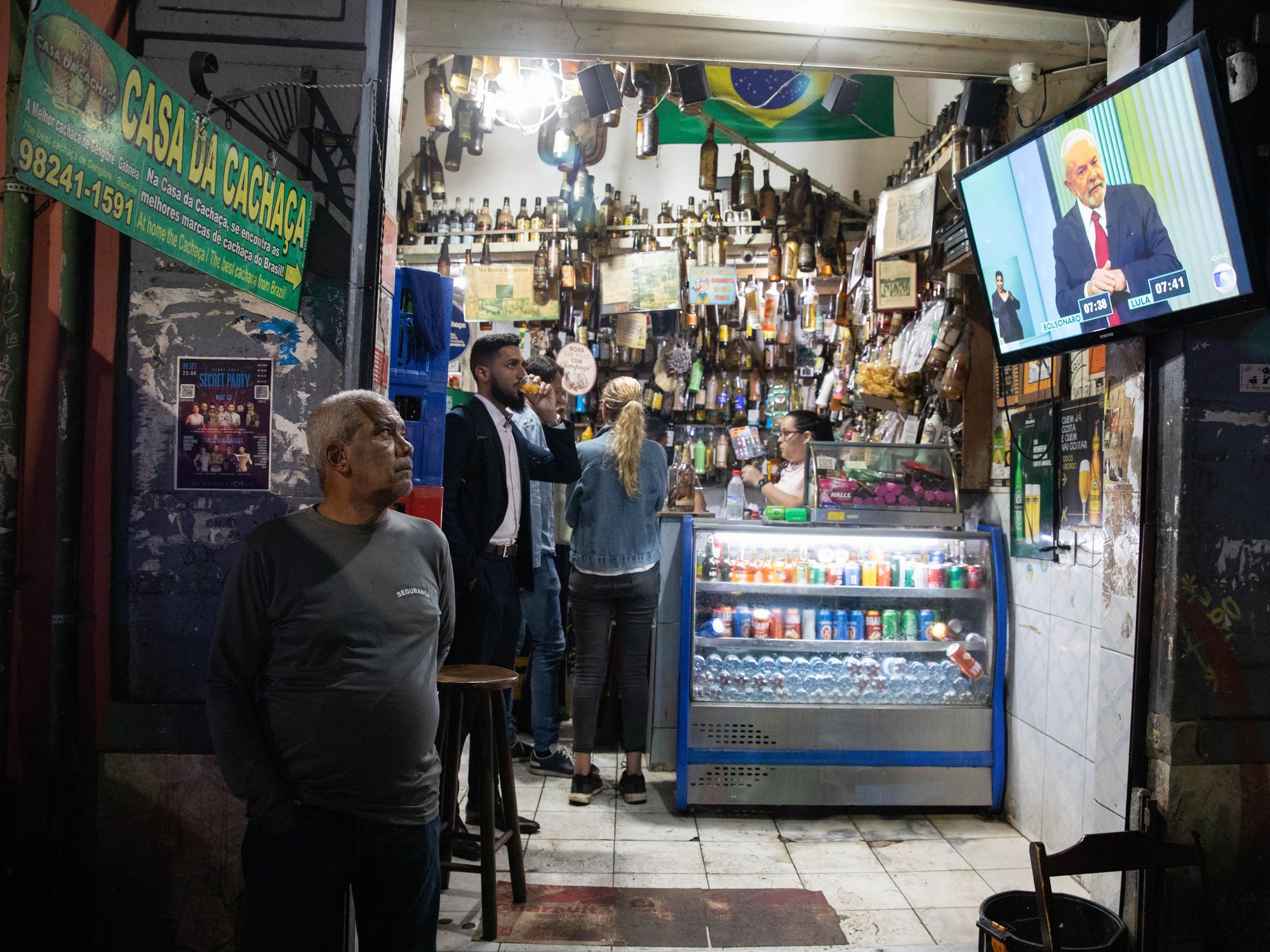 Photo of peple in a local supermarket watching Lula on TV in Rio de Janeiro's Lapa district