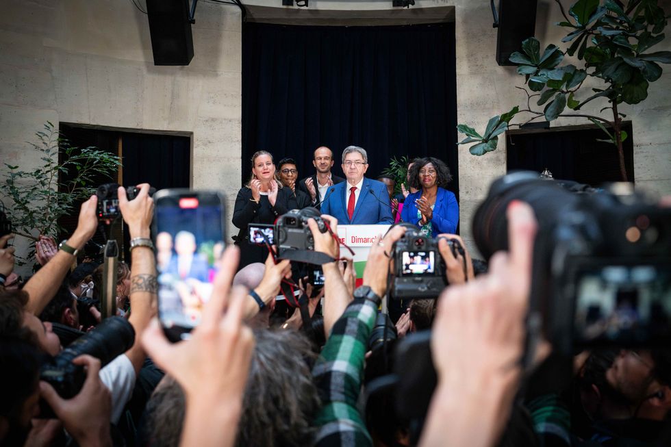 Photo of photographers taking a picture of ​Unbowed (LFI) leader Jean-Luc Melenchon addressing a crowd in Paris on July 8