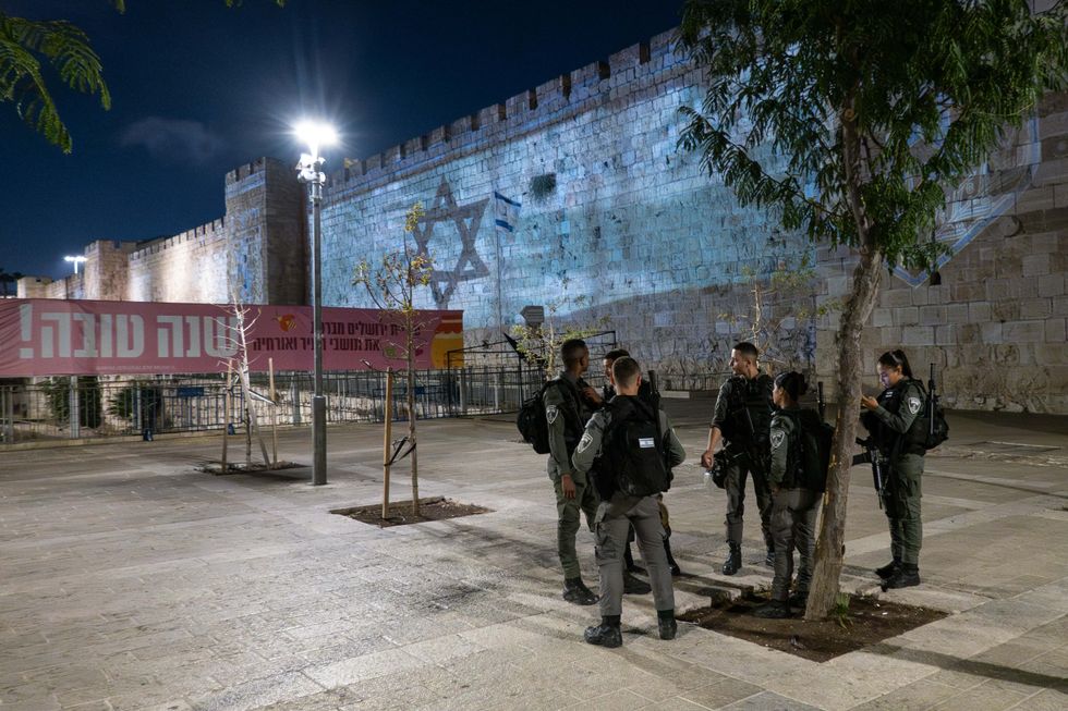 Photo of police forces in Jerusalem on Oct. 10, with the Israeli flag projected on the walls of Jerusalem's Old City in solidarity with the nation.