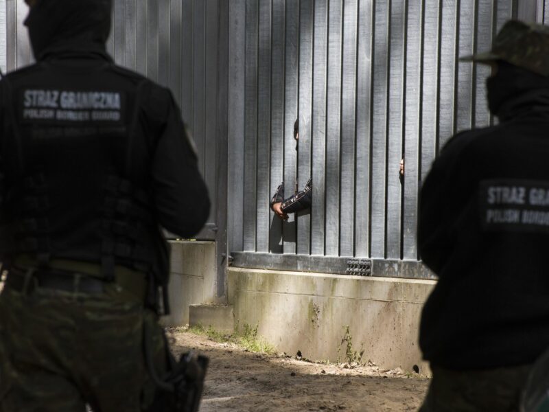 Photo of Polish border guards watching migrants at the country's border with Belarus