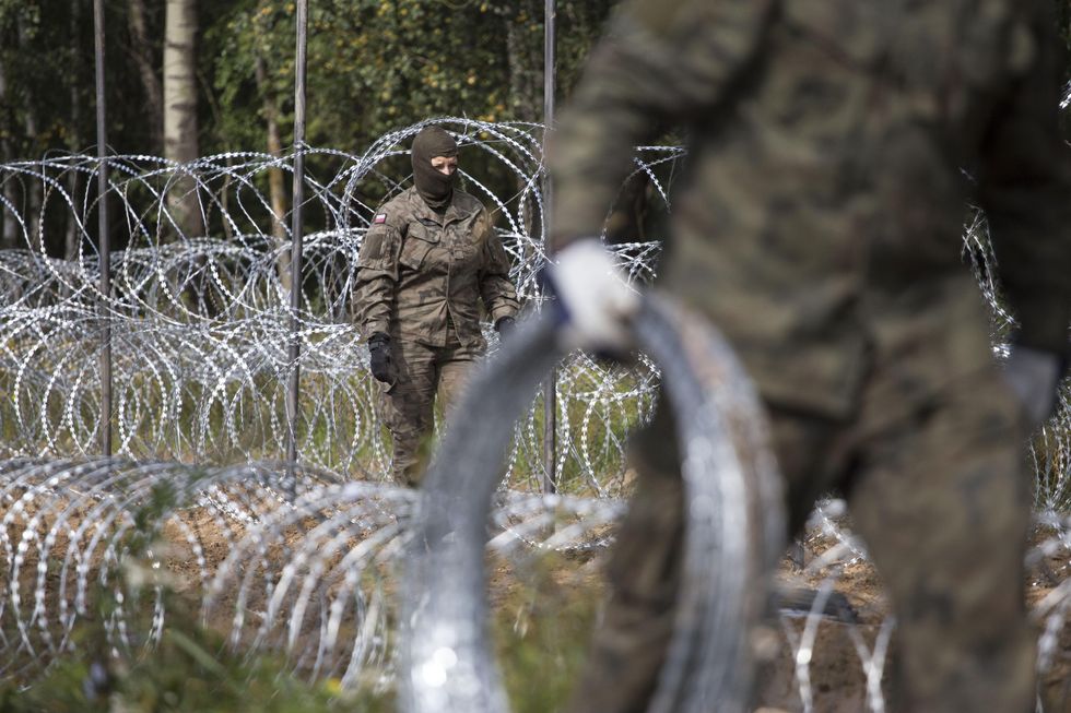Photo of Polish soldiers setting up a barbed wire fence in the Border Zone near Krynki, Belarus