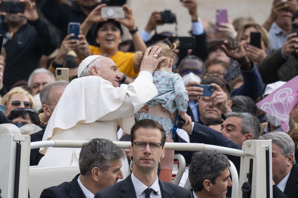 Photo of Pope Francis holding a child