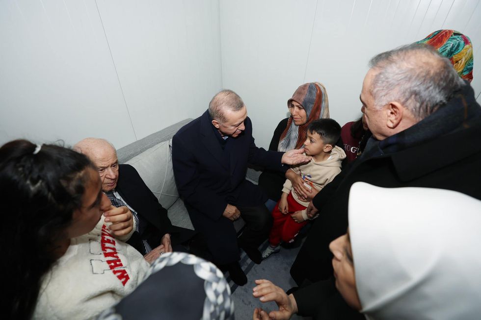 Photo of President Erdogan visiting with earthquake victims.