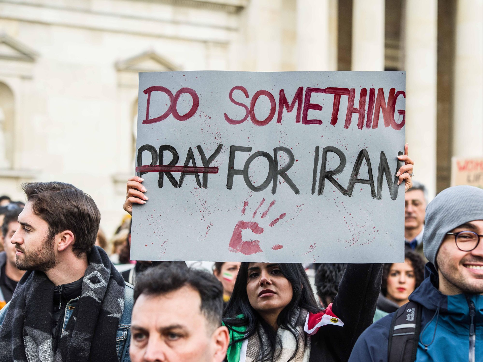 Photo of protersters in Munich, Germany, in November, after the killing of Mahsa Amini. One protester carries a sign that reads "do something for Iran".