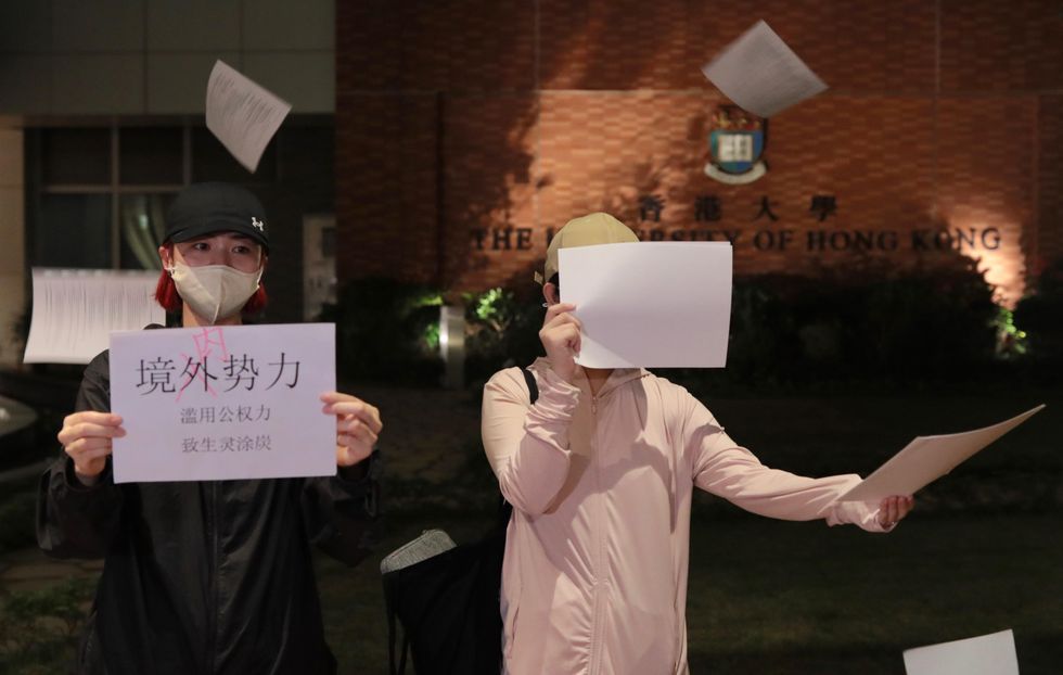 Photo of protesters at Hong Kong University throw white sheets of paper in the air in support of ongoing anti-lockdown demonstrations across mainland China.
