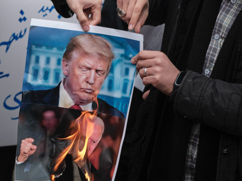 Photo of protesters burning a photo of then U.S. presidential candidates Joe Biden and Donald Trump back in 2020