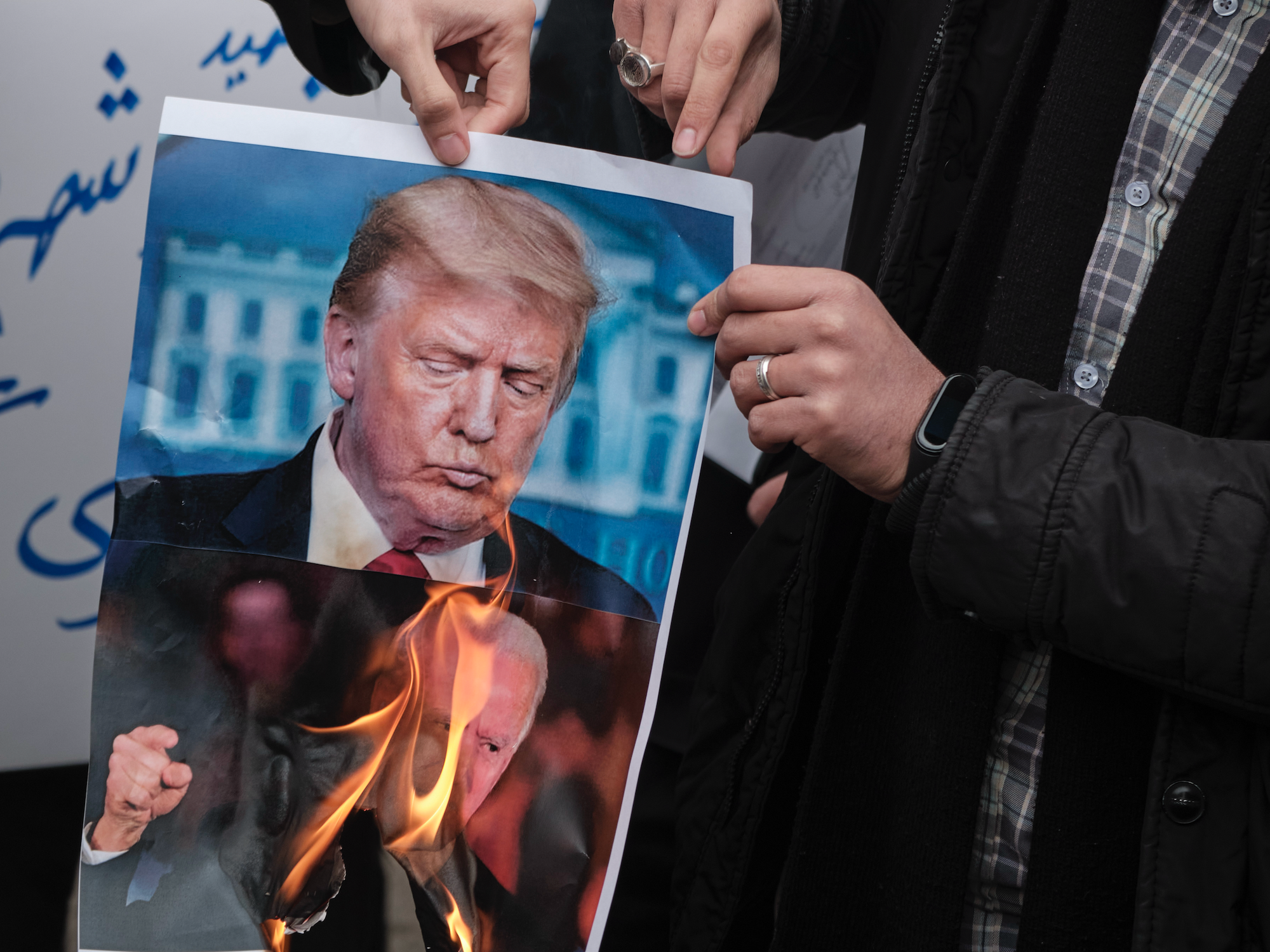 Photo of protesters burning a photo of then U.S. presidential candidates Joe Biden and Donald Trump back in 2020