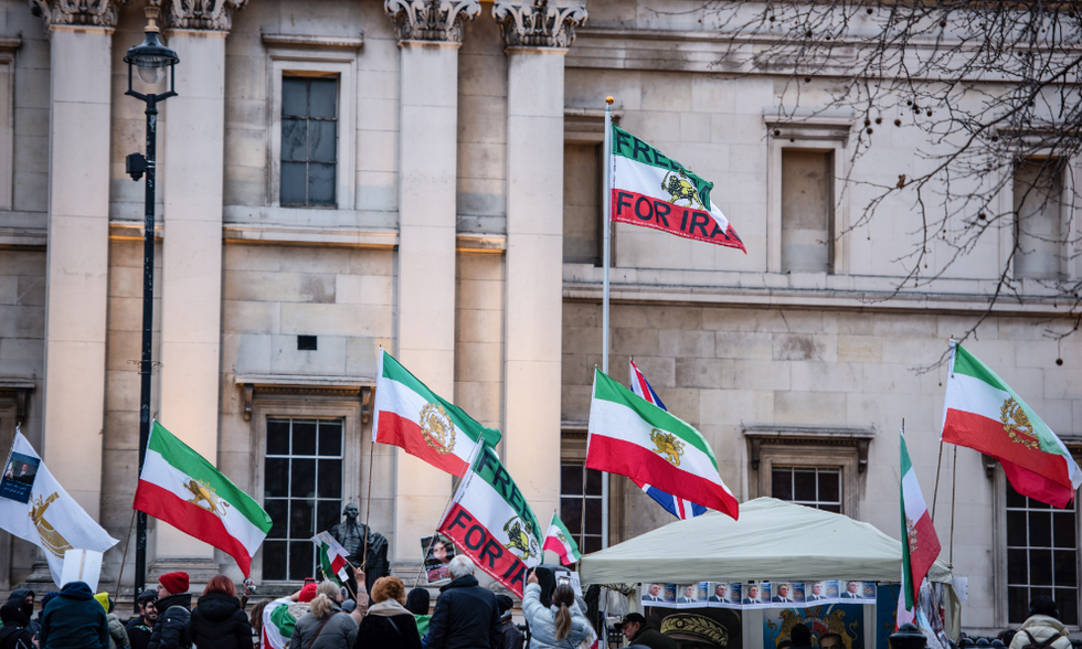 Photo of protesters flying Iranian flags with some bearing the words "Freedom for Iran" as part of a protest against Iranian authorities in London on Jan. 28