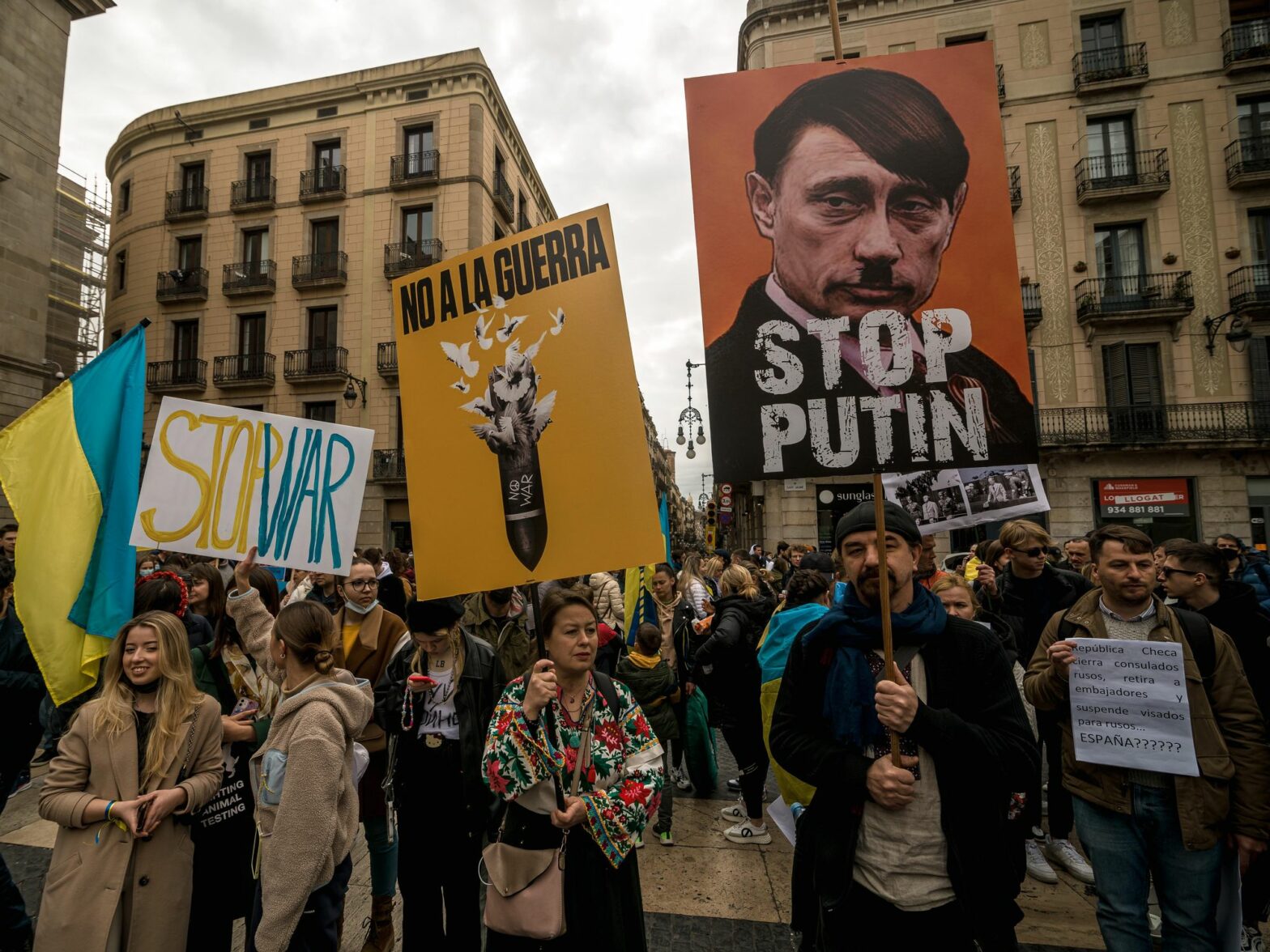 photo of protesters holding signs, including one of putin as hitler