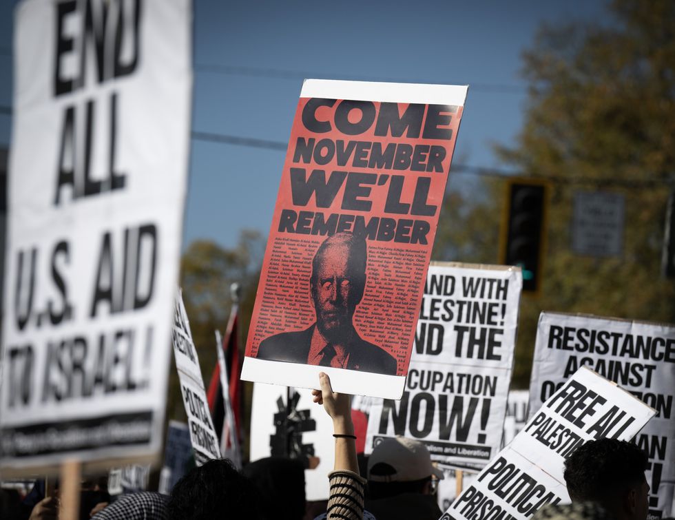 photo of protesters holding up a sign of Joe Biden that says: Come November, We'll Rembember