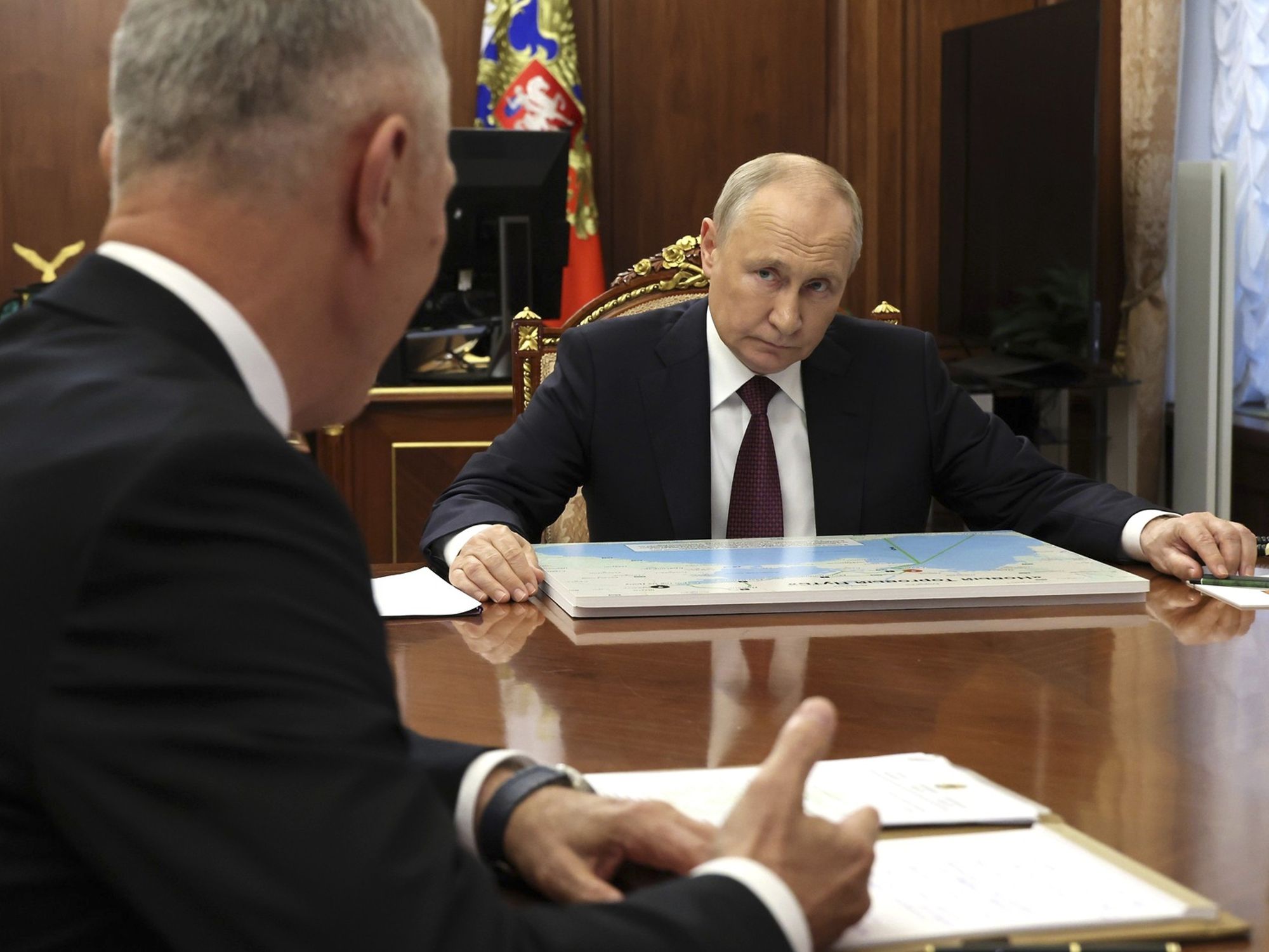 photo of Putin listening to an official in the Kremlin