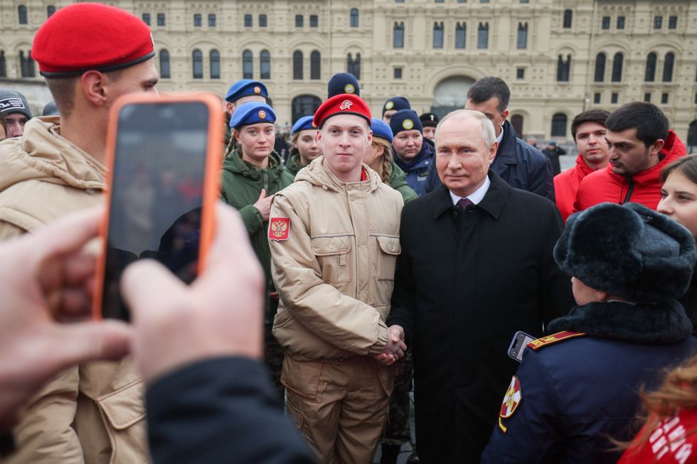 photo of putin posing with a young soldier