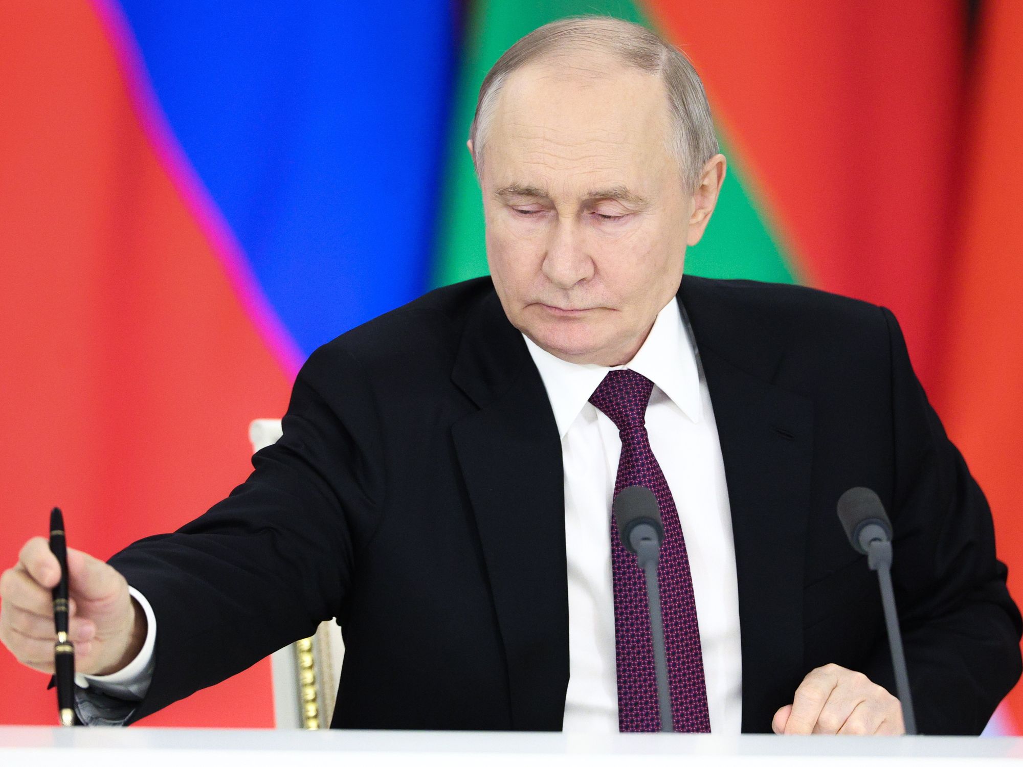 photo of putin with colors of flags behind him