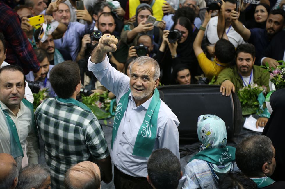 Photo of "reformist" candidate Masoud Pezeshkian raising his fist in a crowd at a rally in Tehran on June 23