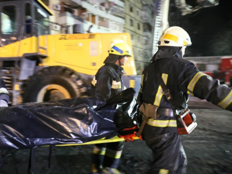 Photo of rescuer workers taking away a corpse in Dnipro