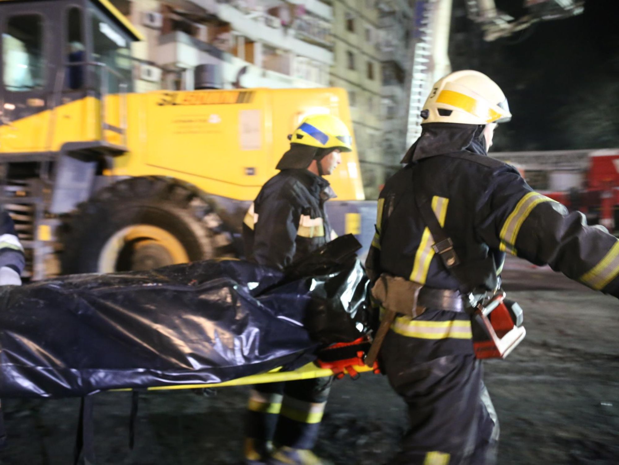 Photo of rescuer workers taking away a corpse in Dnipro