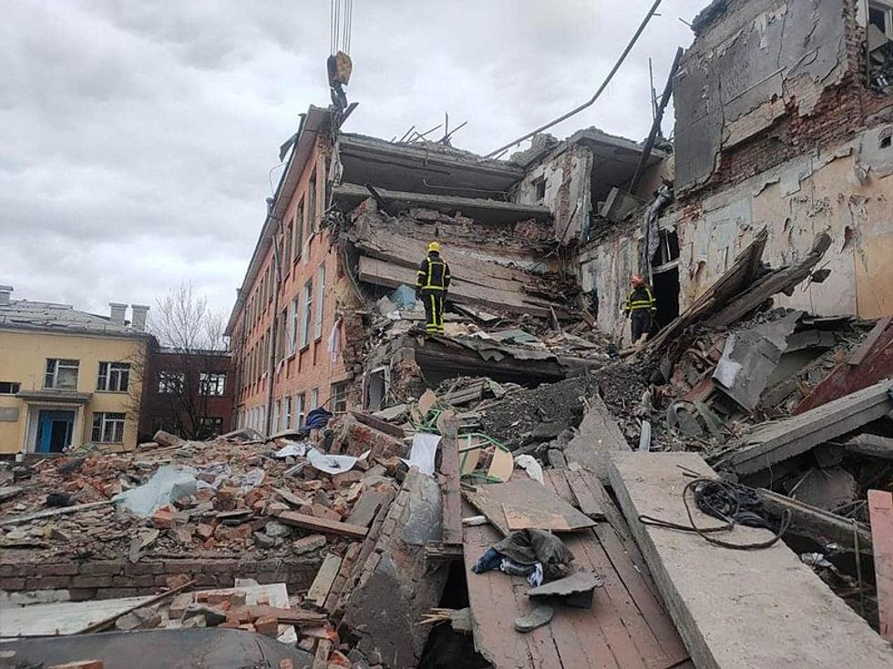 Photo of rescuers checking the remains of a school in Chernihiv in March 2022