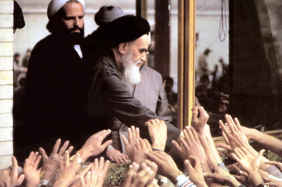 Photo of Ruhollah Khomeini shaking the crowd's hands.