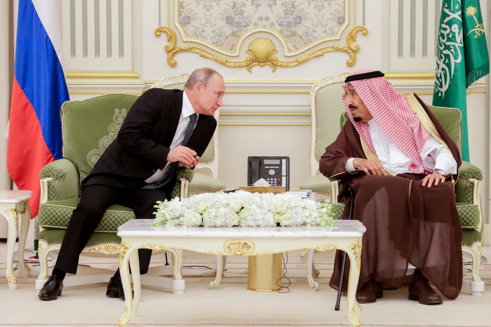 Photo of Russian President Vladimir Putin leaning over to speak with King Salman bin Abdulaziz Al Saud of Saudi Arabia in Riyhad in 2019​