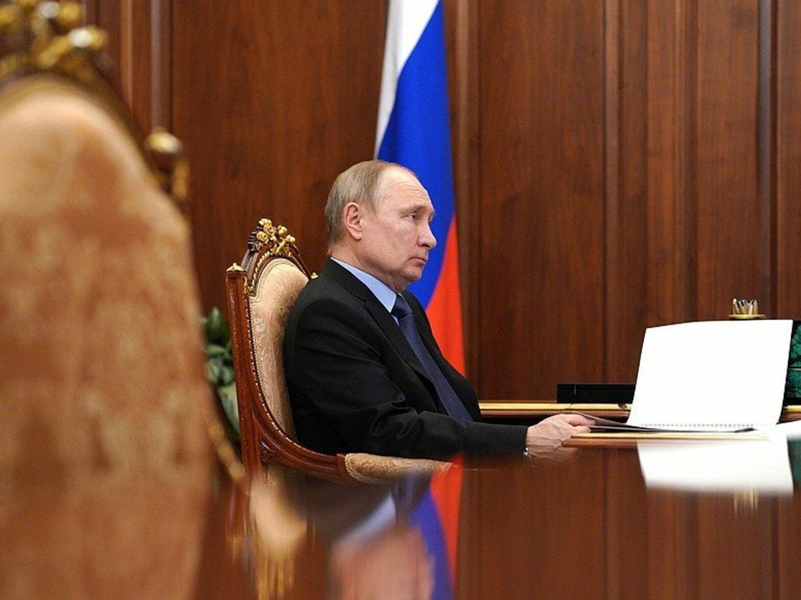 Photo of Russian President Vladimir Putin sitting in Kremlin in Moscow, holding a piece of paper