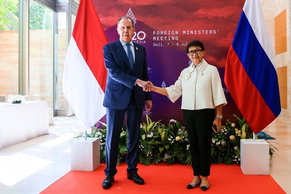 Photo of Russia's Foreign Minister Sergei Lavrov shaking hands with his Indonesian counterpart Retno Marsudi