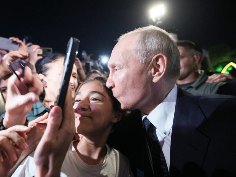 Photo of Russia's President Vladimir Putin kissing a girl's head as he poses for pictures with citizens in Derbent, on the Caspian Sea, on June 28.