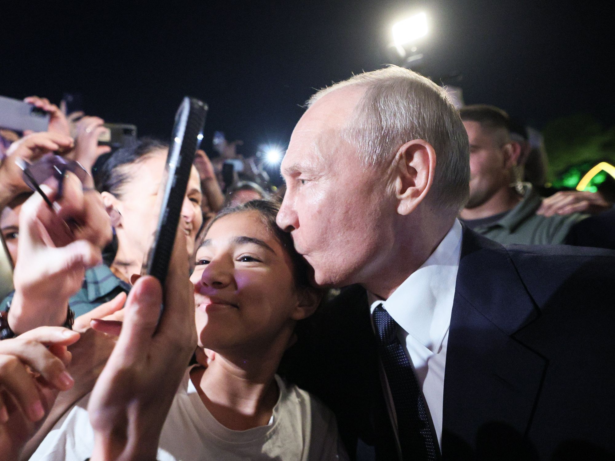 Photo of Russia's President Vladimir Putin kissing a girl's head as he poses for pictures with citizens in Derbent, on the Caspian Sea, on June 28.