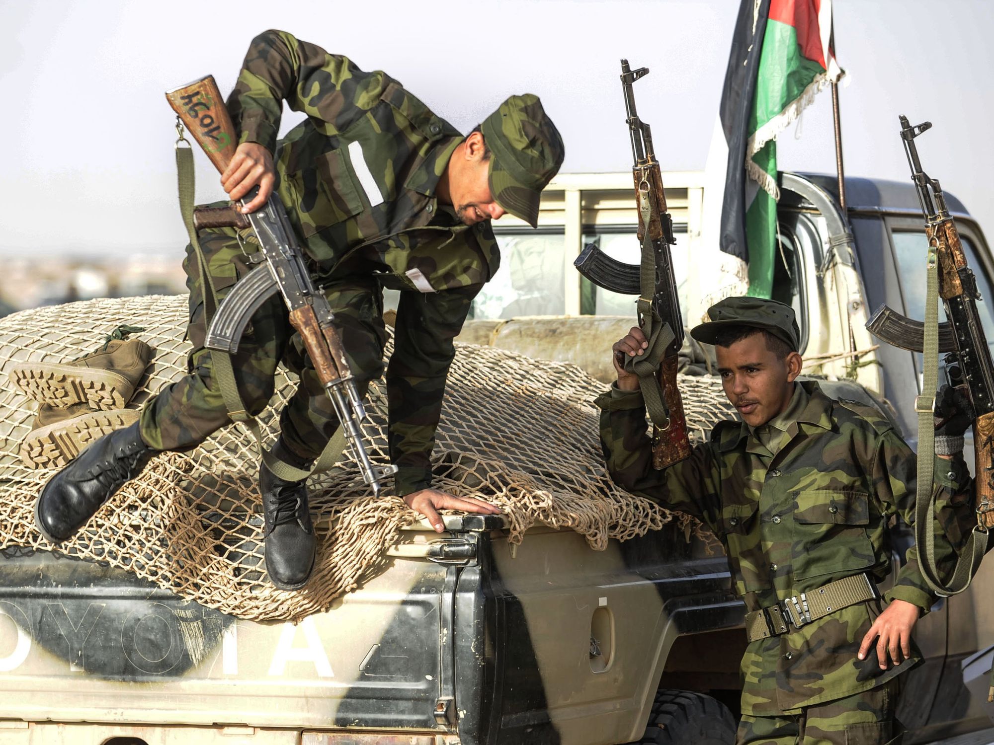 Photo of Sahrawi soldiers, one jumping out of a pickup truck, in Tindouf, Algeria