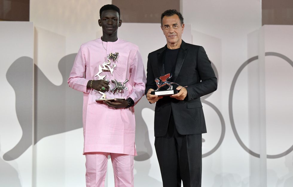 photo of Sarr winning Best Young Actor and Garrone winning Best Director men, holding trophies at last year's Venice Film Festival