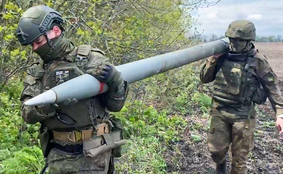 Photo of servicemen of Russia's Western Military District load a shell into a Grad multiple rocket launcher.