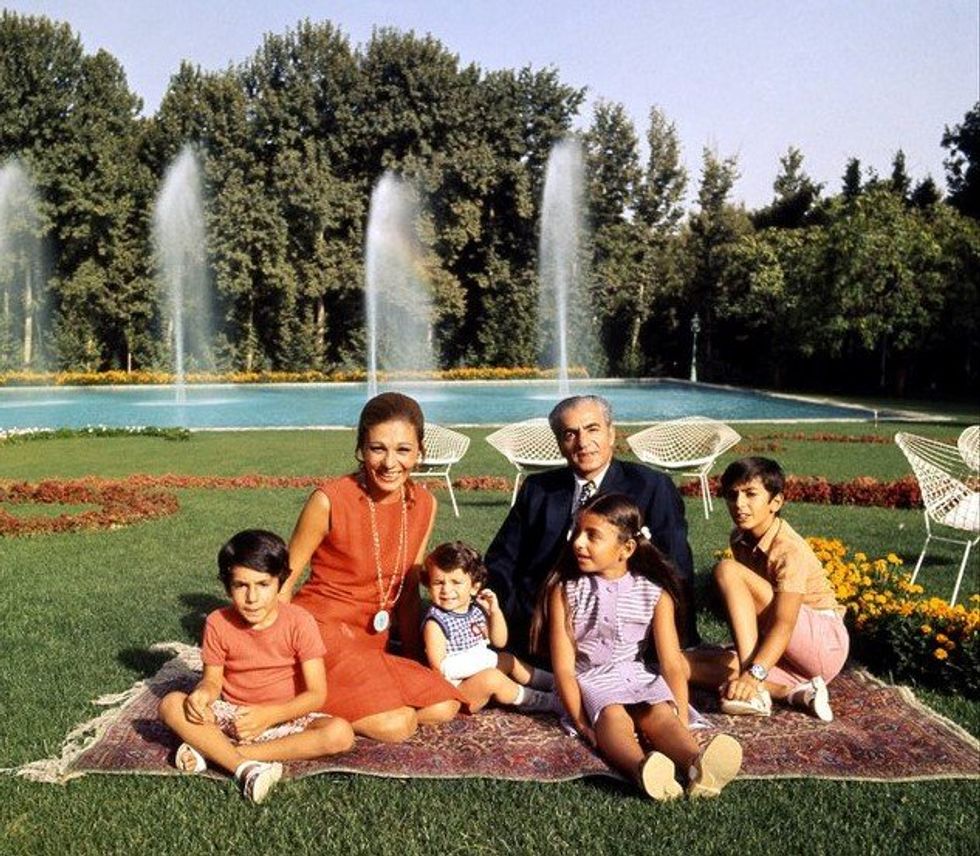Photo of Shah Mohammad Reza Pahlavi and his wife Farah Pahlavi with their four children in ​1973 in a garden.
