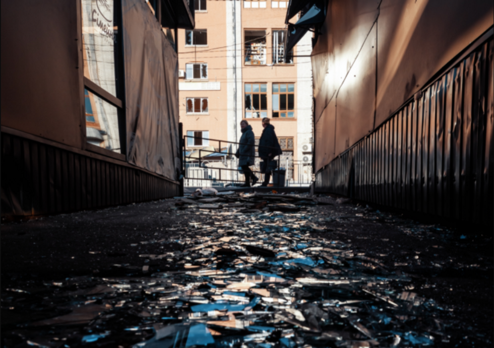 Photo of shards of glass on the floor as people walk by in Kyiv, on March 21