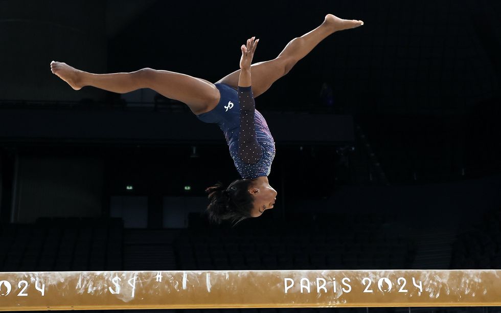 photo of Simone biles flipping on the balance beam