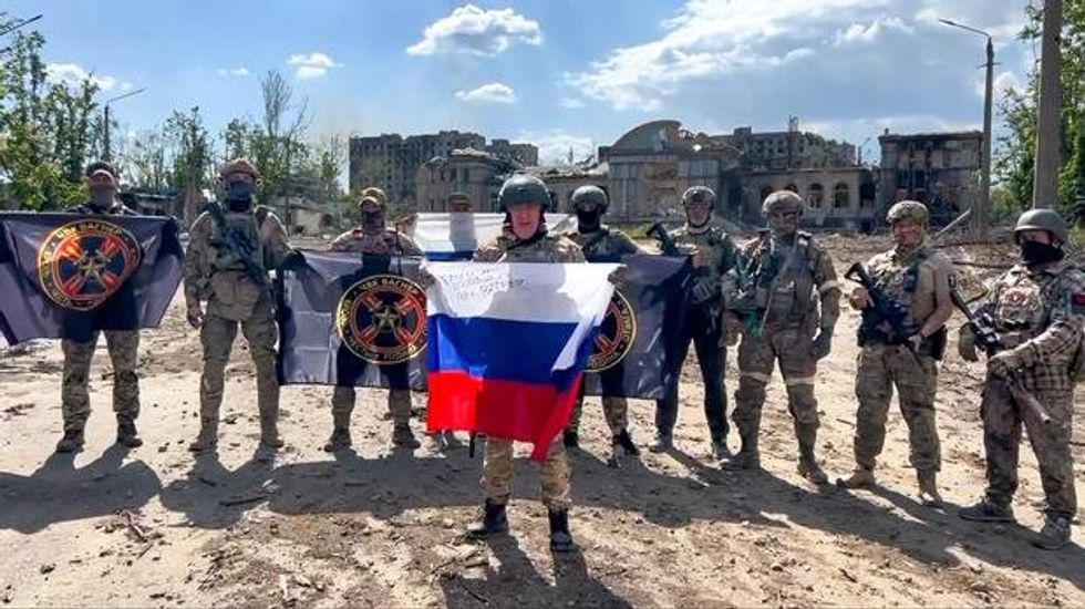 Photo of soldiers holding up flags