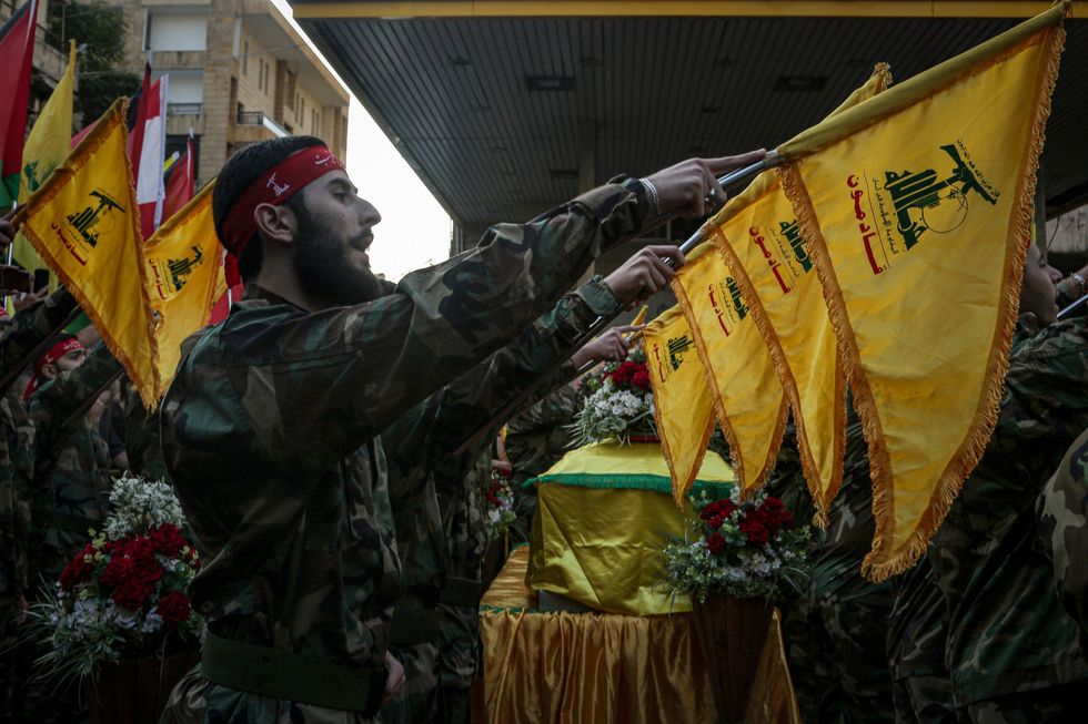 photo of soldiers holding yellow flags in front of a coffin