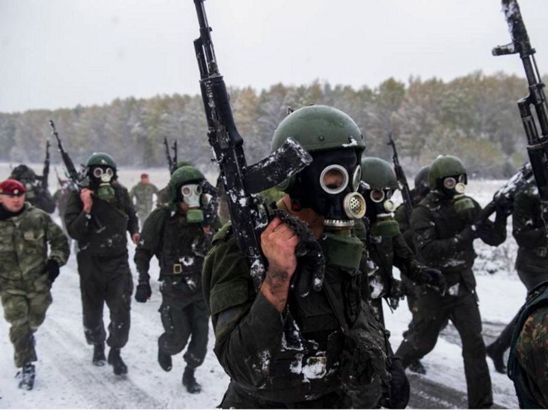 photo of soldiers marching in the snow with automatic rifles