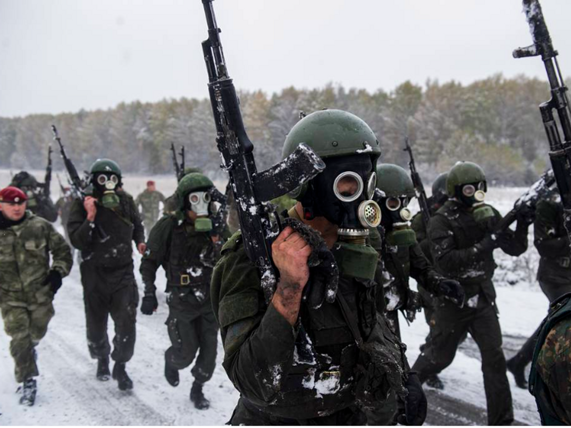 photo of soldiers marching in the snow with automatic rifles