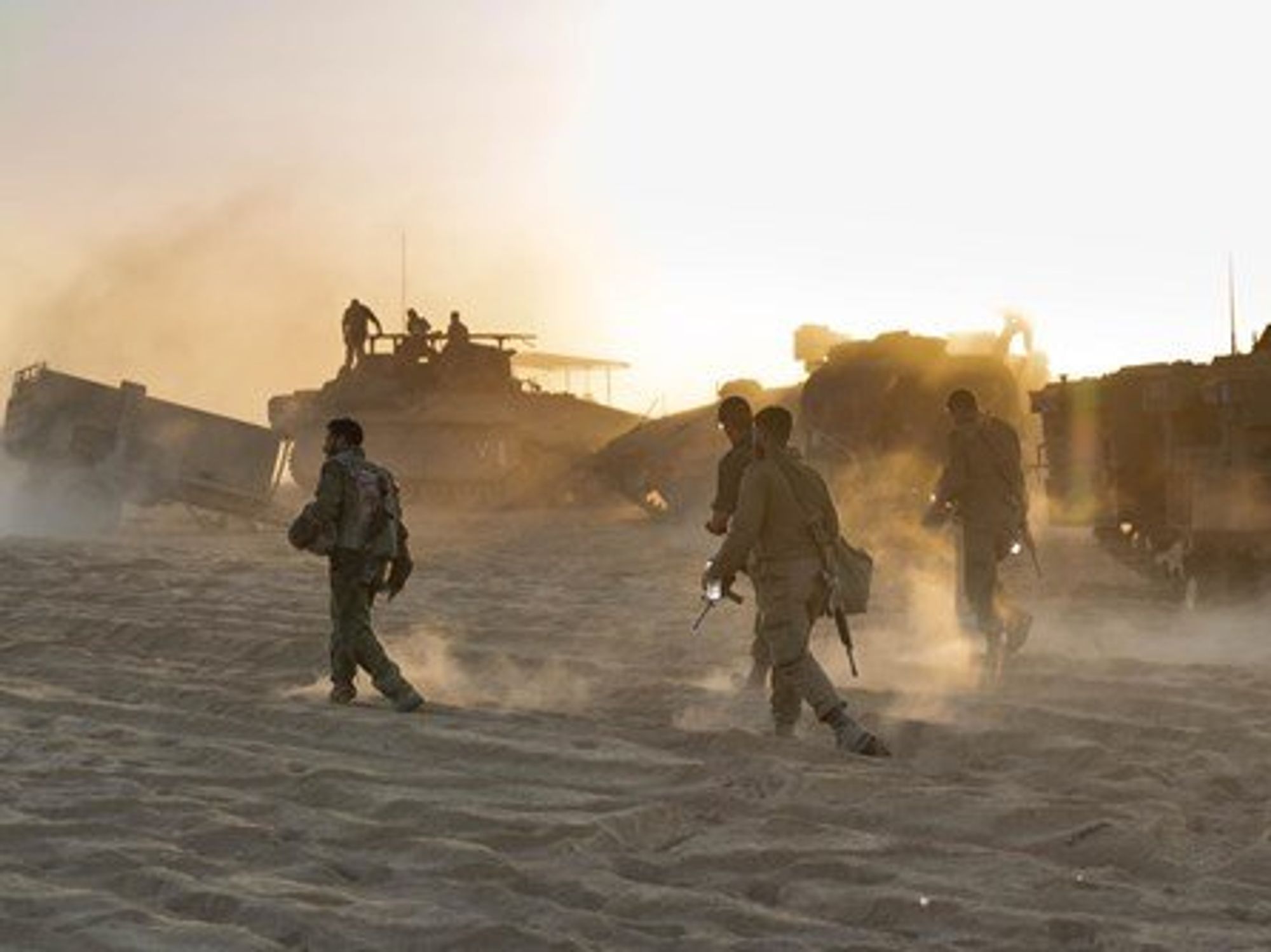 photo of soldiers walking in desert with tanks